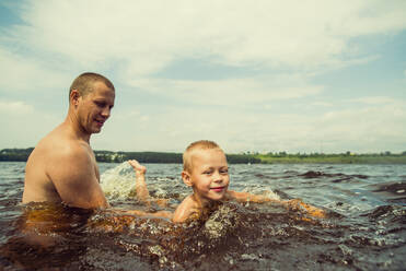 Kaukasischer Vater und Sohn schwimmen im See - BLEF11847