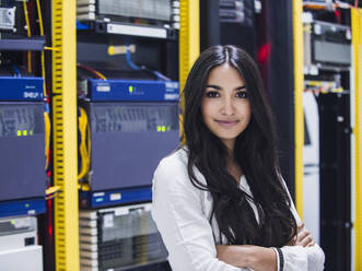 Mixed race technician smiling in server room - BLEF11881