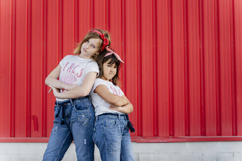 Sisters standing in front of a red wall - ERRF01609