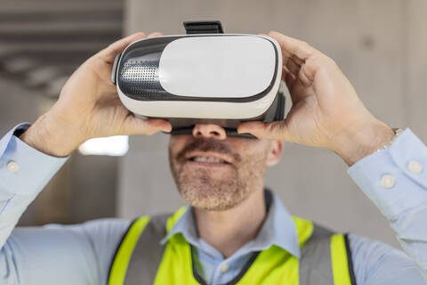 Architekt mit VR-Brille auf der Baustelle, lizenzfreies Stockfoto