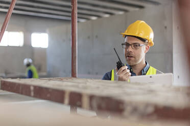 Architekt mit Walkie-Talkie und Laptop auf der Baustelle - ZEF16161