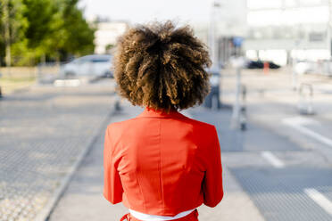 Back view of young woman wearing fashionable red suit jacket - GIOF06885