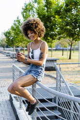 Porträt einer tätowierten jungen Frau, die im Sommer ein Selfie mit ihrem Smartphone macht - GIOF06908