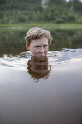 Porträt eines lächelnden Jungen in einem See - VPIF01383