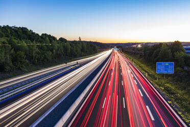 Deutschland, Baden-Württemberg, Leonberg, Autobahn A8, Schnellstraße, Straße, Fahrspuren, Straßenverkehr, viel Verkehr, Fahrzeuge, Dämmerung, Lichter, Lichtspuren - WDF05344