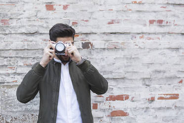 Junger Mann beim Fotografieren mit Kamera - JUNF01682