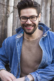 Porträt eines lachenden jungen Mannes mit Brille und Jeansjacke - JUNF01685