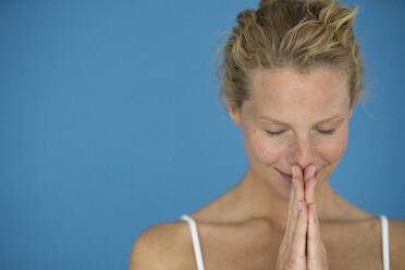 Lächelnde blonde Frau mit geschlossenen Augen, meditierend - JOSF03544