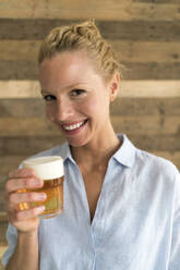 Porträt einer blonden Frau mit einem Glas Bier - JOSF03561