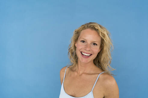 Porträt einer schönen blonden Frau, blauer Hintergrund - JOSF03574