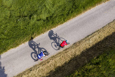 Triathleten fahren mit dem Fahrrad auf einer Landstraße, Deutschland - STSF02143