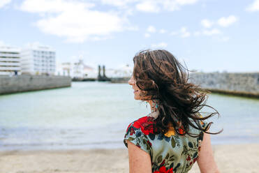 Rückansicht einer Frau mit weißem Sonnenhut am Hafen von Arrecife, Spanien - KIJF02508