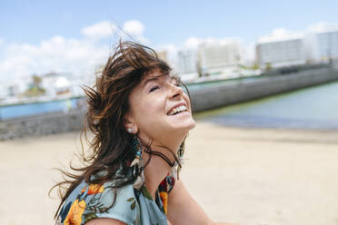 Portrait of smiling woman at the beach in Arrecife, Spain - KIJF02510