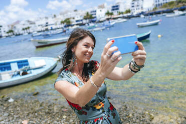 Frau macht ein Selfie am Hafen - KIJF02520