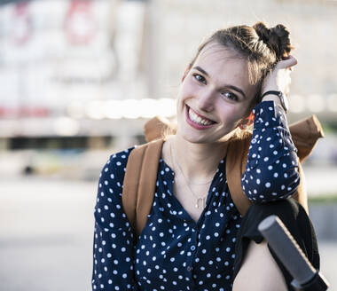 Porträt einer lächelnden jungen Frau mit Motorroller - UUF18293