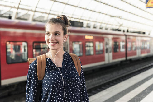 Portrait of smiling young woman at the train station - UUF18299