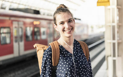 Portrait of smiling young woman at the train station - UUF18301