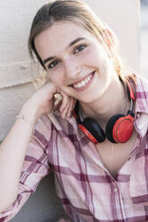 Portrait of smiling young woman with headphones - UUF18324