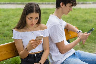 Junges Paar benutzt Smartphone in einem Park - MGIF00632
