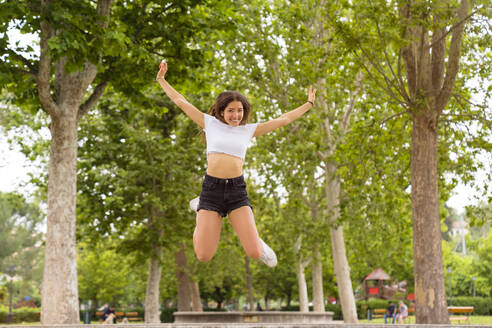 Junge Frau springt im Park - MGIF00639