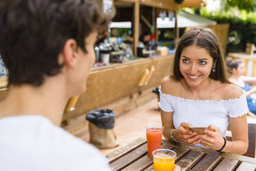 Junges Paar in einem Café, Frau benutzt Smartphone - MGIF00648