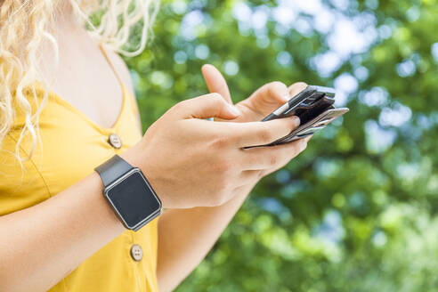 Frau mit Smartphone und Digitaluhr - TCF06163