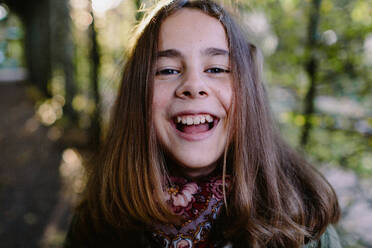 Portrait of laughing young girl in a park - OGF00080