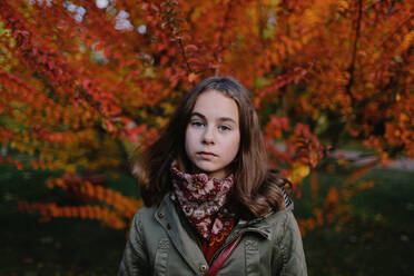 Portrait of young girl in a park, autumn tree in the background - OGF00082