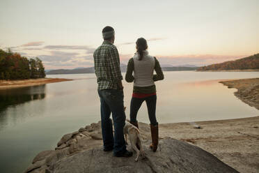 Couple and dog admiring remote lake - BLEF11959