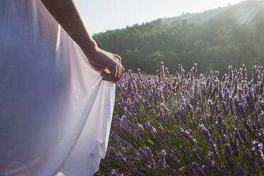 Caucasian woman walking in field of flowers - BLEF12012