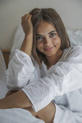 Caucasian woman smiling in bed - BLEF12063