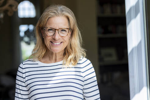 Portrait of smiling mature woman wearing glasses - FMKF05761