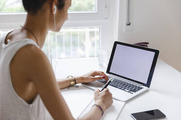 Junge Frau beim Lernen mit ihrem Laptop zu Hause - MRAF00407