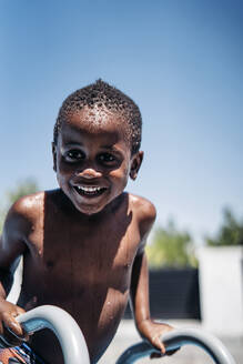 Happy little boy on a ladder of the swimming pool - OCMF00532