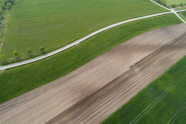 Luftaufnahme eines Traktors auf einem landwirtschaftlichen Feld, Franken, Bayern, Deutschland - RUEF02273
