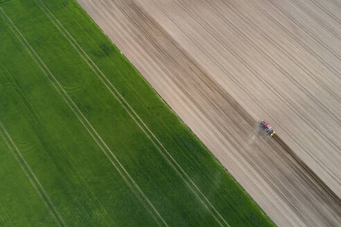 Luftaufnahme eines Traktors auf einem landwirtschaftlichen Feld, Franken, Bayern, Deutschland - RUEF02274