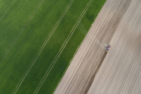 Luftaufnahme eines Traktors auf einem landwirtschaftlichen Feld, Franken, Bayern, Deutschland - RUEF02275