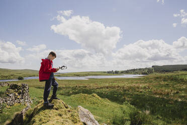 Junge mit Blick auf Karte, Cairngorms, Schottland, UK - NMS00335