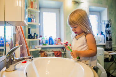 Caucasian girl brushing her teeth in bathroom - BLEF12085