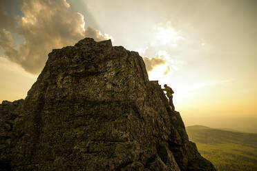 Caucasian hiker climbing on rock formation - BLEF12094