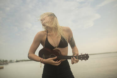 Kaukasische Frau spielt Ukulele am Strand - BLEF12153