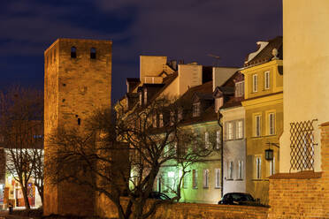 Stadtmauerturm und traditionelle Häuser bei Nacht, Warschau, Polen - ABOF00426