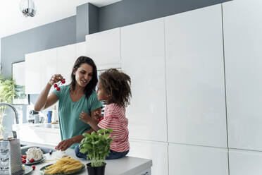 Mother and daughter cooking in kitchen together - ERRF01671