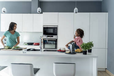 Glückliche Mutter und Tochter beim gemeinsamen Kochen in der Küche - ERRF01672