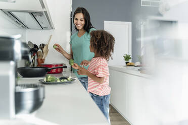 Mother and daughter cooking in kitchen together - ERRF01675