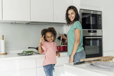 Glückliche Mutter und Tochter beim gemeinsamen Kochen in der Küche - ERRF01678