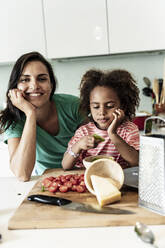 Porträt einer glücklichen Mutter und Tochter, die gemeinsam in der Küche kochen - ERRF01711