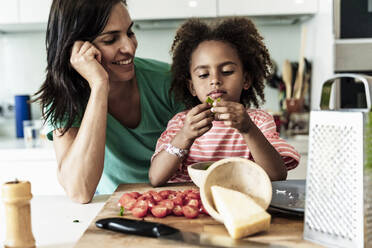 Happy mother and daughter cooking in kitchen together - ERRF01712