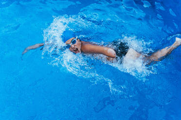 Junge paralympische Schwimmerin beim Kraulen im Schwimmbecken - JCMF00077