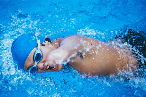Junge paralympische Schwimmerin beim Kraulen im Schwimmbecken - JCMF00078